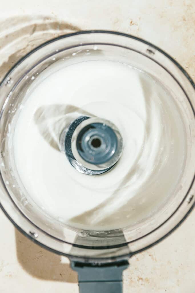 Creamy keto peanut butter ice cream mixture in a food processor.