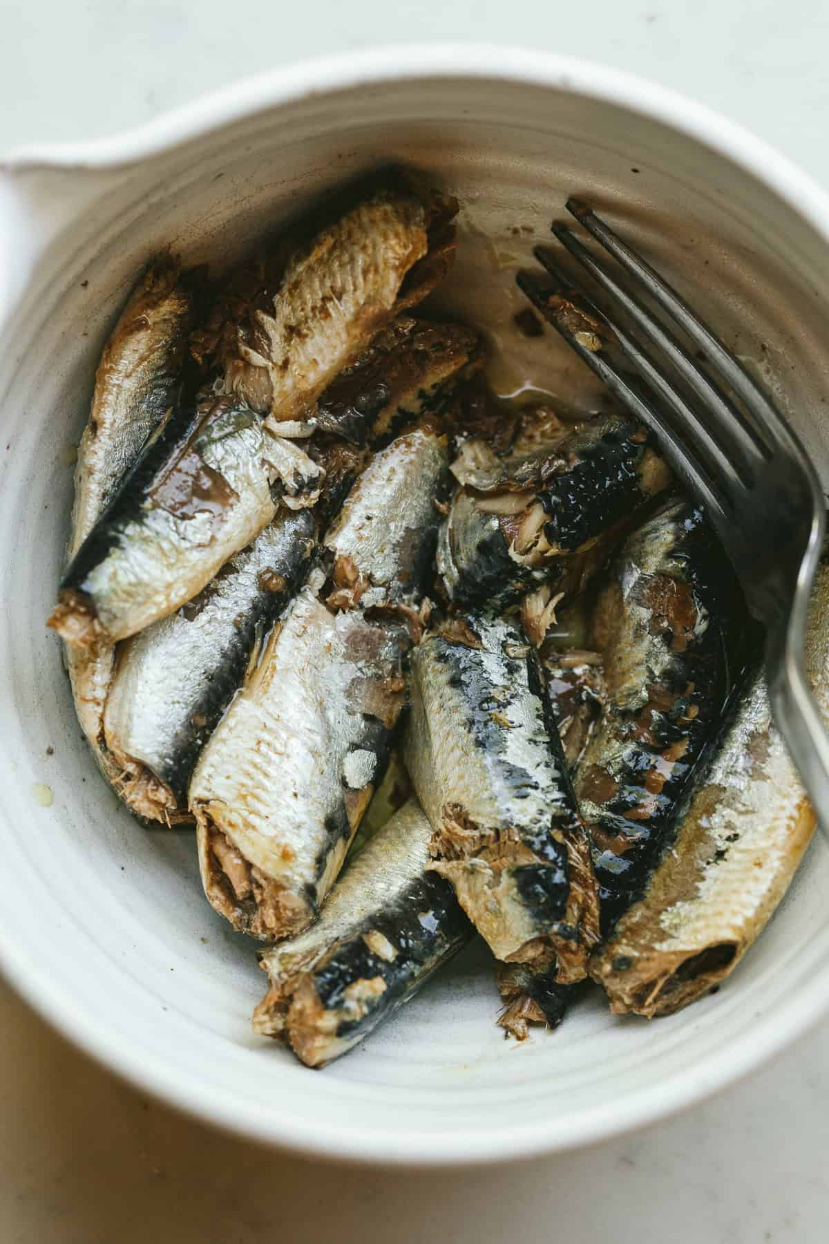 Sardines in a bowl with a fork.