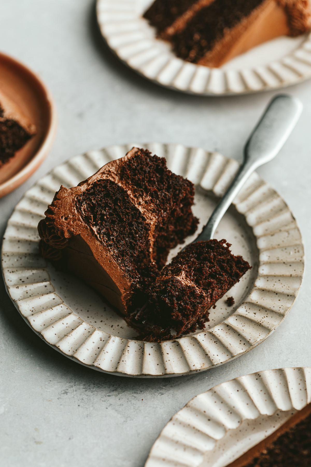 A slice of keto chocolate cake with a bite taken out of it.