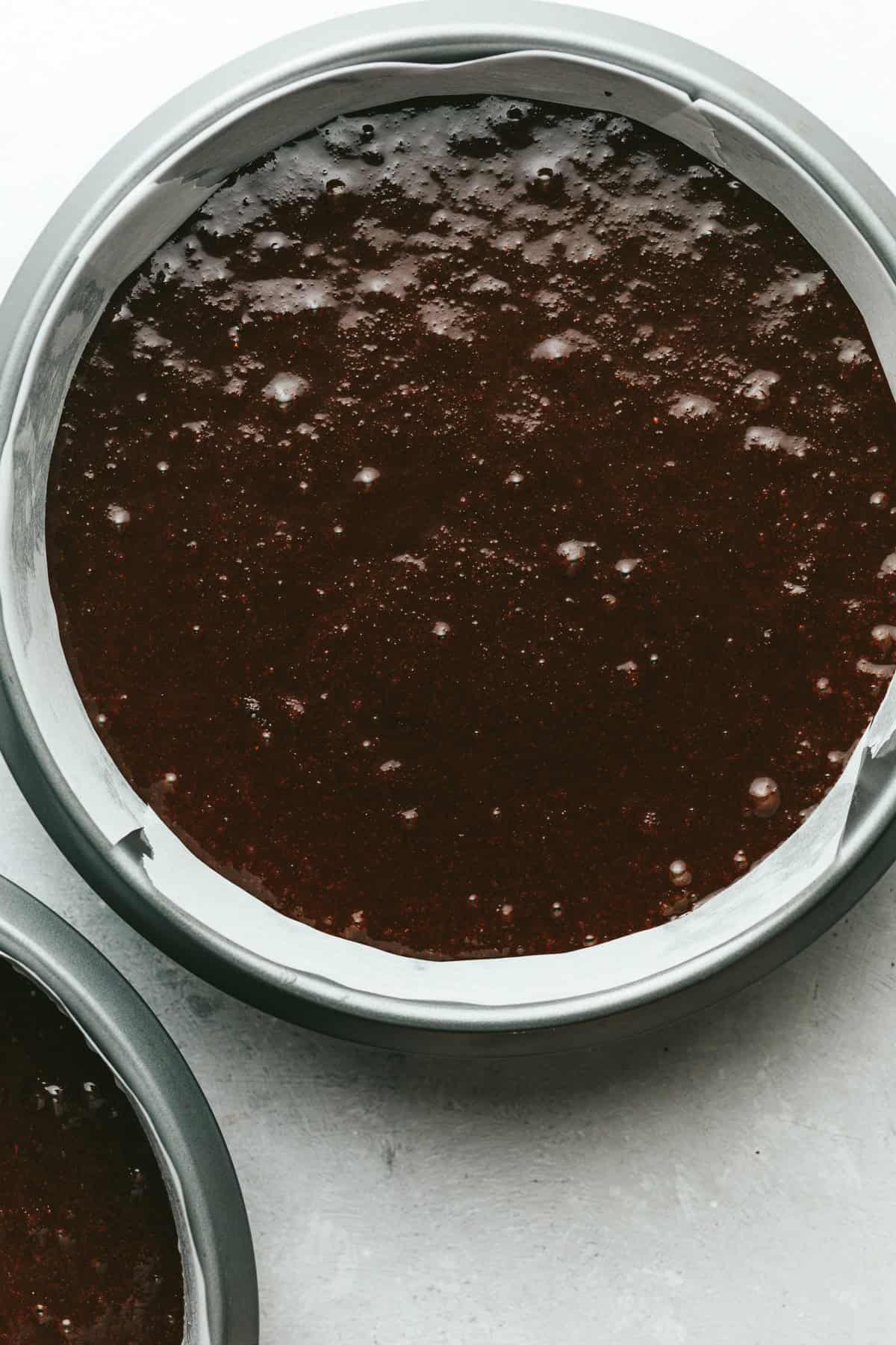 Keto chocolate cake batter in two cake pans, ready for the oven.