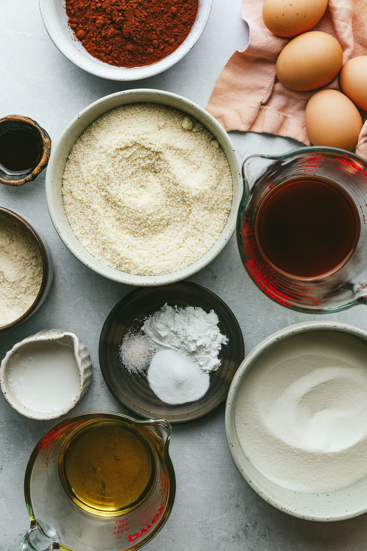 Ingredients for keto chocolate cake arranged in small dishes.