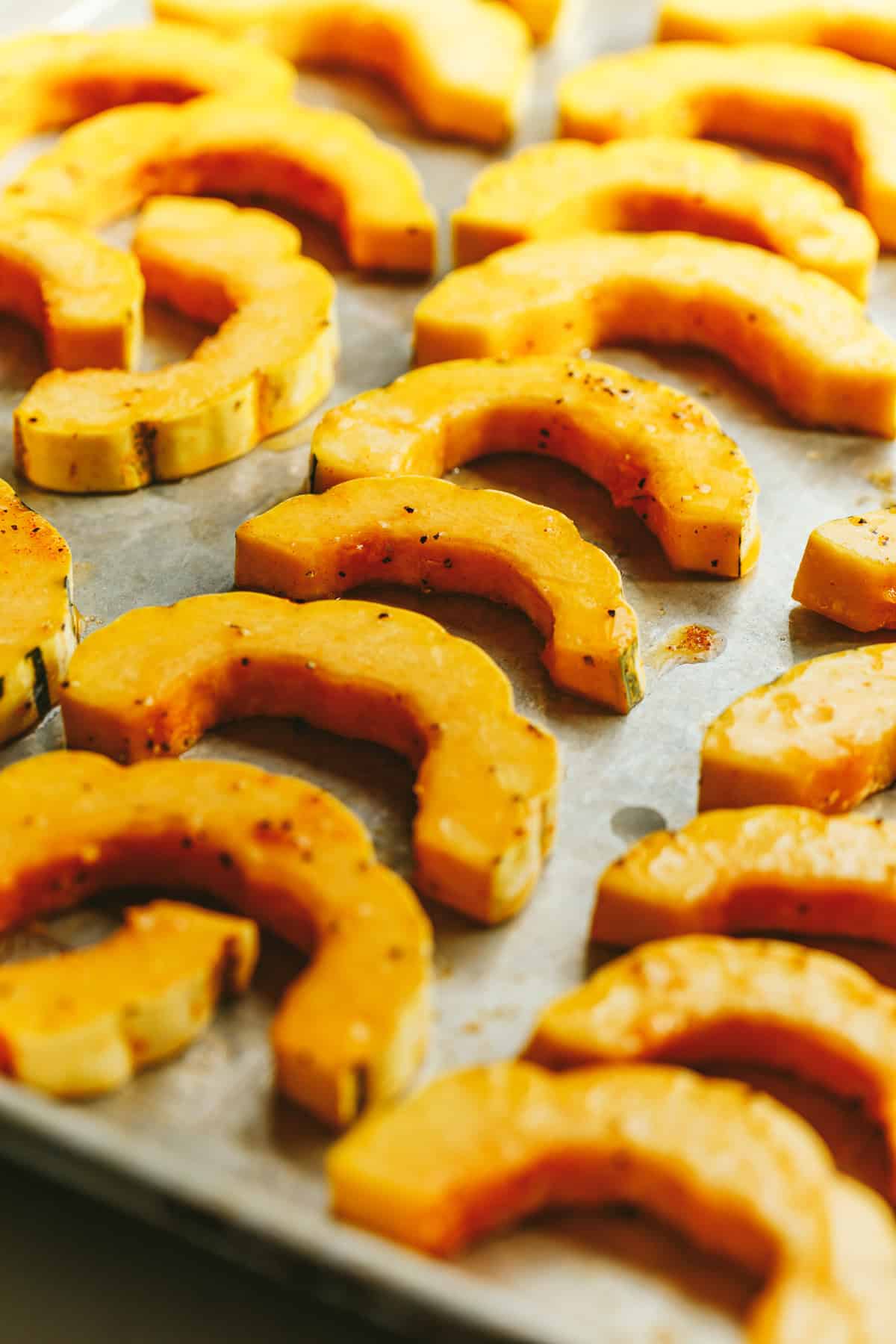 Delicata squash on a baking sheet before roasting.