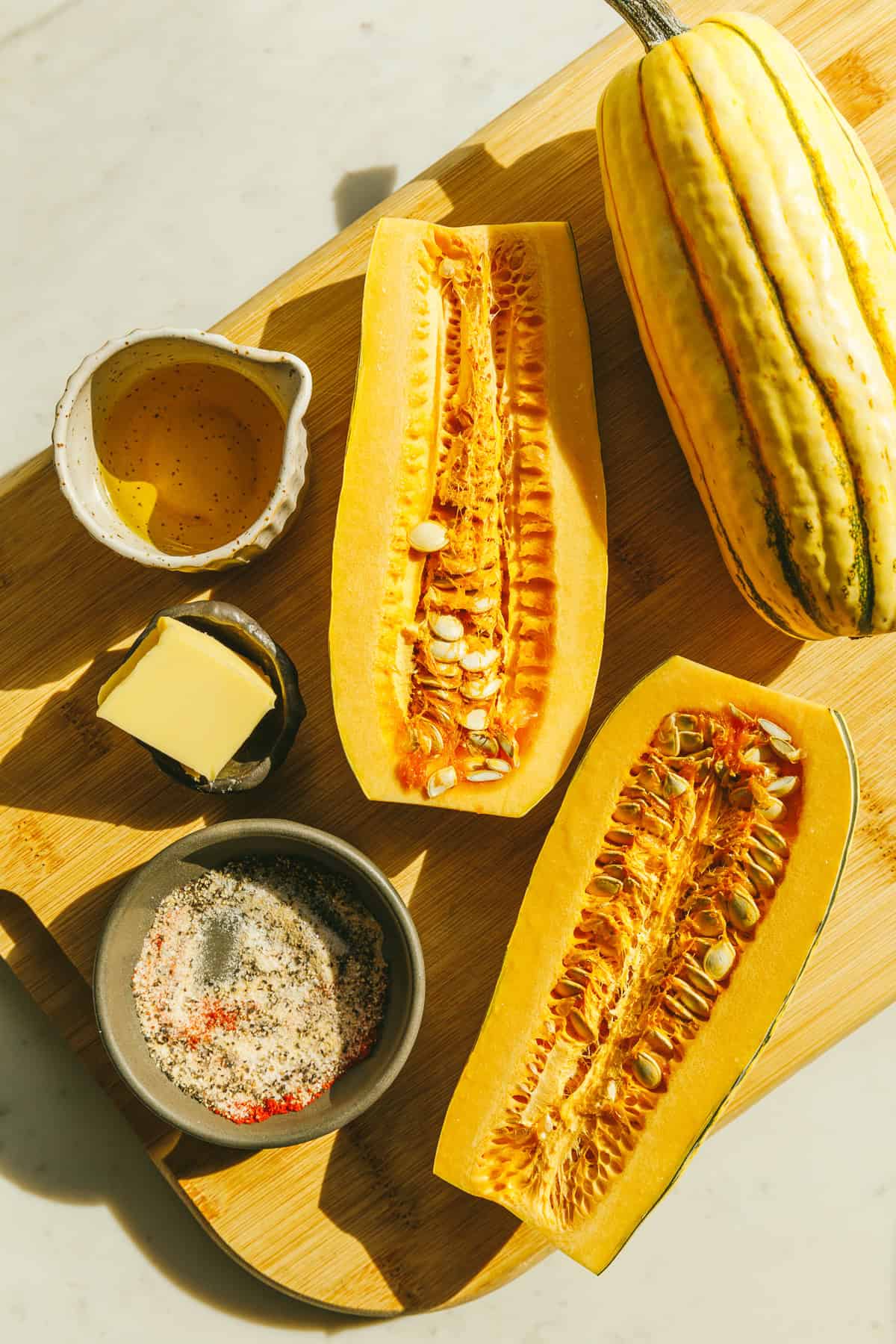 Ingredients on a cutting board for roasted delicata squash recipe.